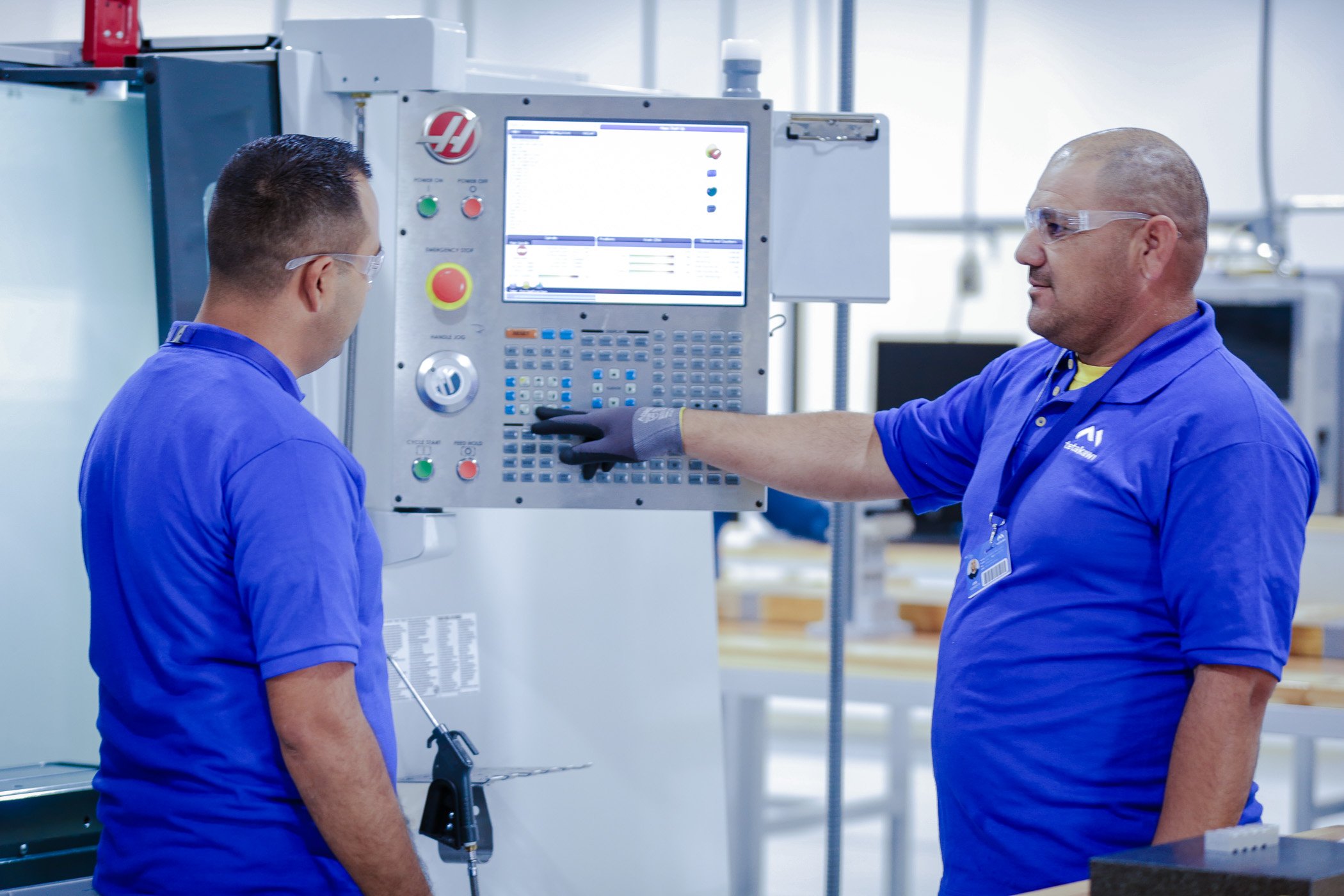 Skilled workers in Mexico operating a CNC machine